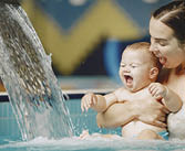 Little cute baby boy. Mother with son. Family playing in a water.