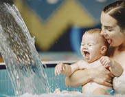Little cute baby boy. Mother with son. Family playing in a water.