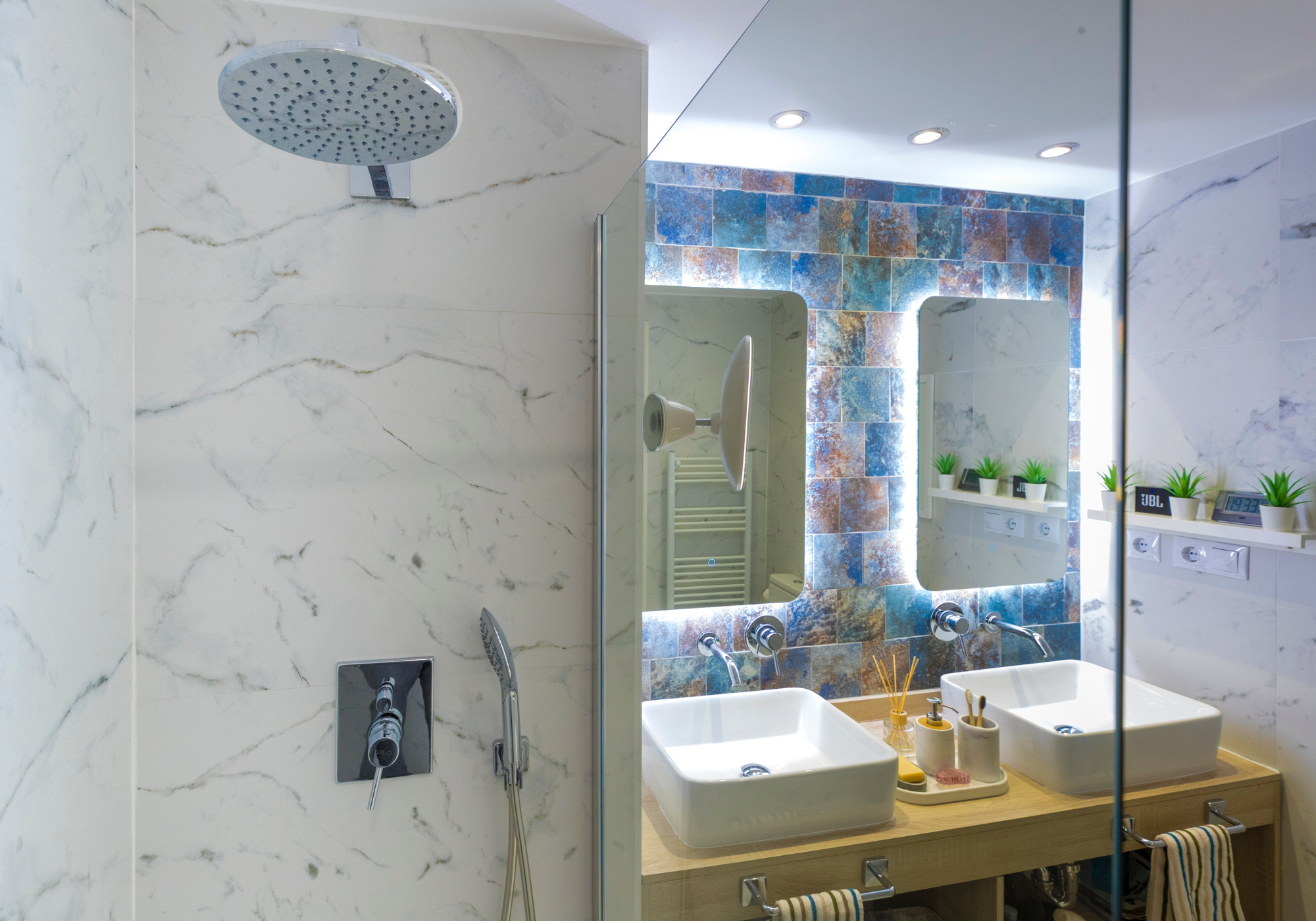 Baño Marble Carrara Blanco con revestimiento cerámico Ocean Baño con revestimiento cerámico efecto mármol Marble Carrara Blanco y Ocean en la zona de ducha