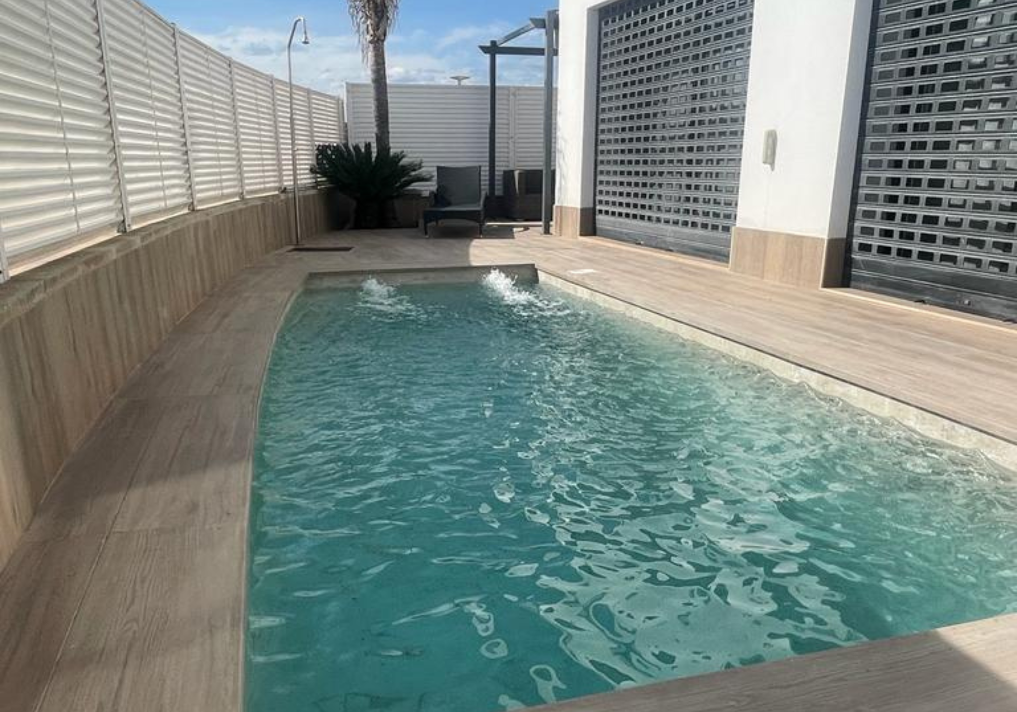 Revestimiento cerámico efecto madera en piscina Piscina con revestimiento cerámico efecto madera, diseño natural y alta resistencia al agua.