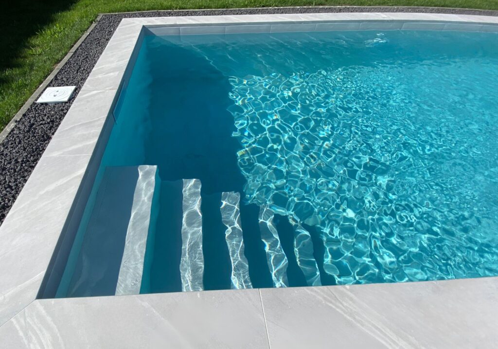 efecto-profundidad-color-agua-piscina.jpg Degradado natural del color del agua en una piscina según la profundidad sobre peldaños de gres porcelánico.