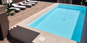 Permanently built swimming pool finished with Gres Aragón porcelain stoneware, showcasing visual continuity and low maintenance requirements.